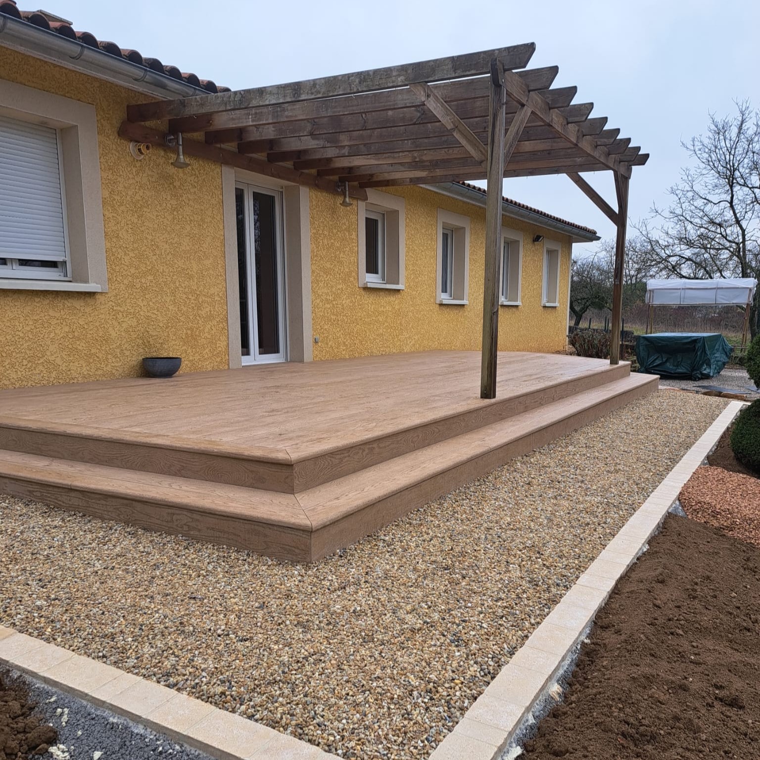 Bardage en bois installé sur une maison avec terrasse, solution de bardage extérieur esthétique et durable