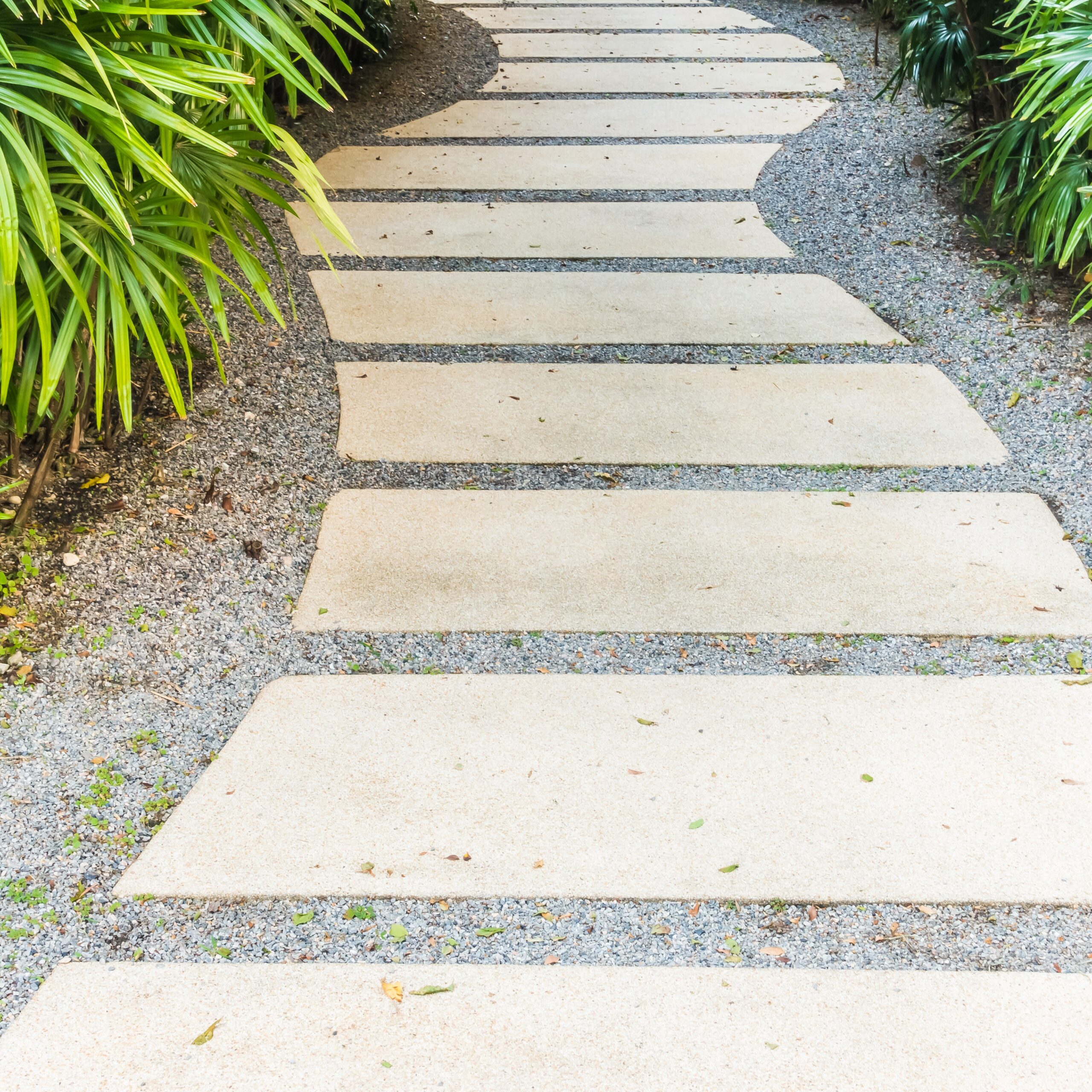 Allée de jardin en maçonnerie paysagère avec bordure en pierre et dallage extérieur pour structurer les circulations.