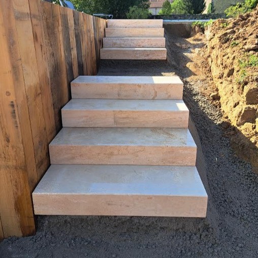 Escalier extérieur en maçonnerie paysagère pour faciliter l’accès et structurer un terrain en pente.